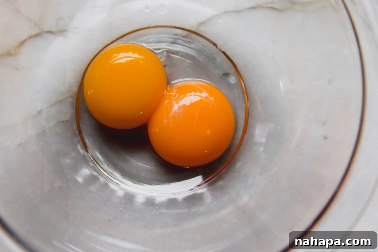 Velvety Greek Lemon Chicken Avgolemono 4 Whisked egg yolks in a bowl, ready for tempering.