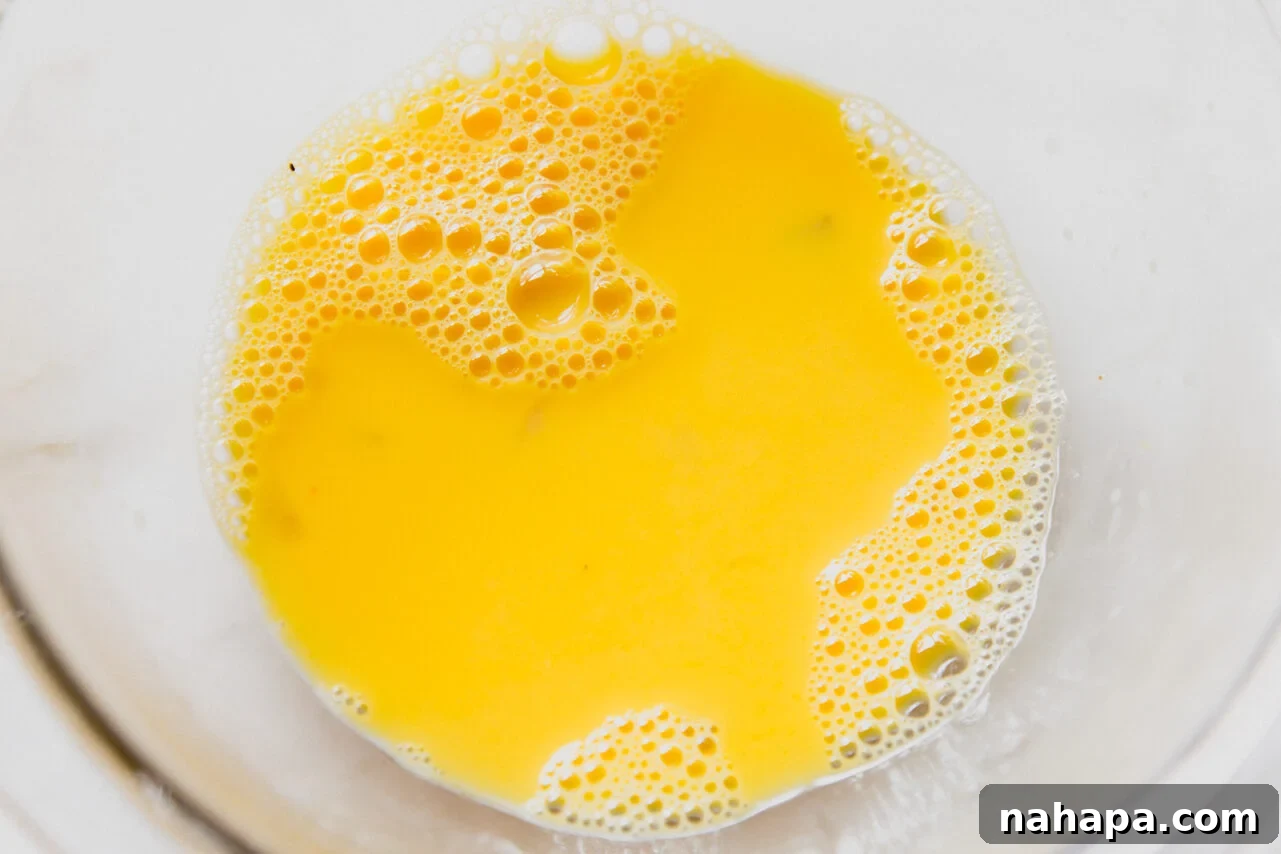 Velvety Greek Lemon Chicken Avgolemono 5 Slowly pouring hot broth into whisked egg yolks to temper them.