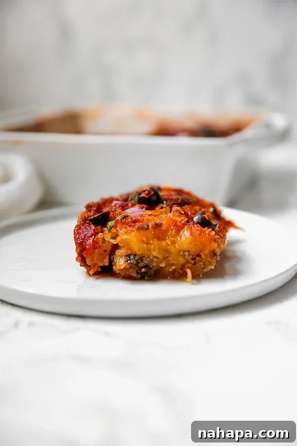 Close-up of a bubbling spaghetti squash pizza casserole in a white baking dish.
