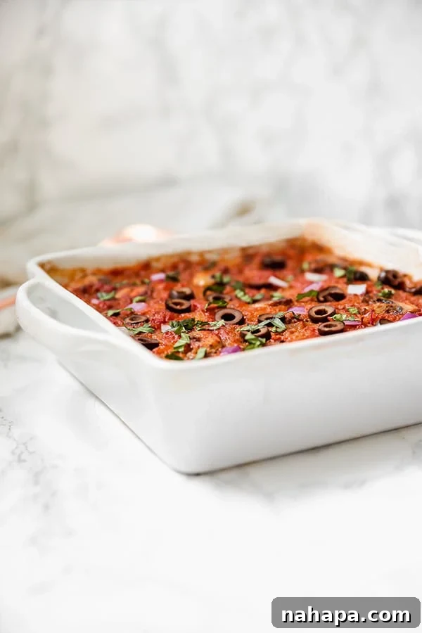 A serving of spaghetti squash casserole with a fork, showing the texture and ingredients.