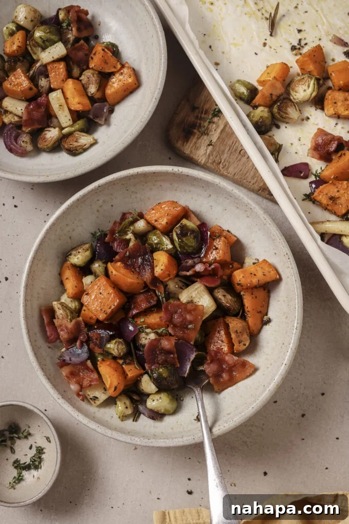 Bountiful Harvest Veggie Hash 2 A beautifully plated bowl of Harvest Vegetable Hash, featuring crispy bacon bits and roasted root vegetables, with a baking sheet visible in the background.
