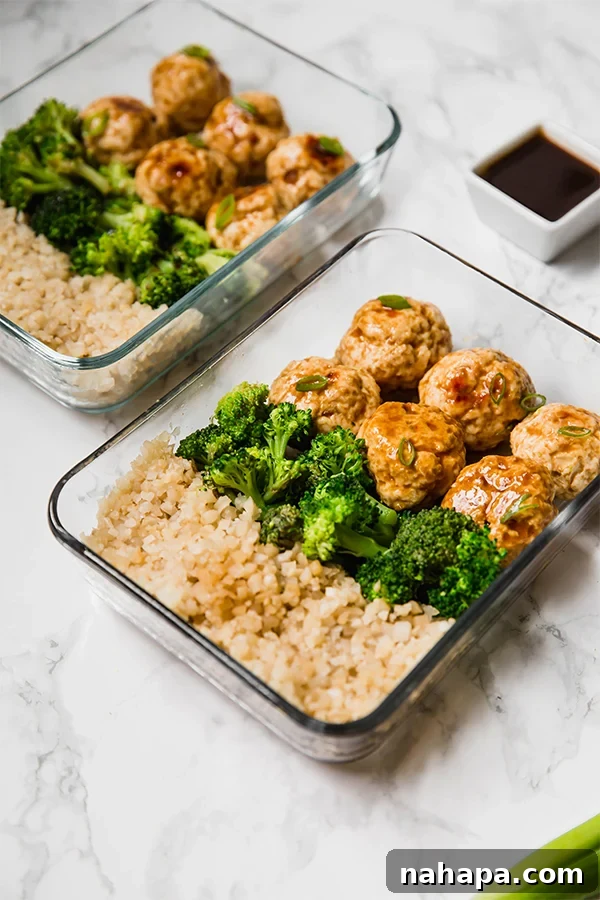 Multiple glass meal prep containers showcasing a vibrant assembly of teriyaki chicken meatballs, bright green broccoli, and fluffy cauliflower rice, perfectly portioned for the week.