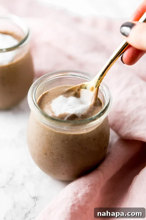 Guilt-Free Paleo Peppermint Mocha Collagen Pudding 4 A serving of peppermint mocha collagen pudding, topped with fluffy whipped coconut cream and a spoon.