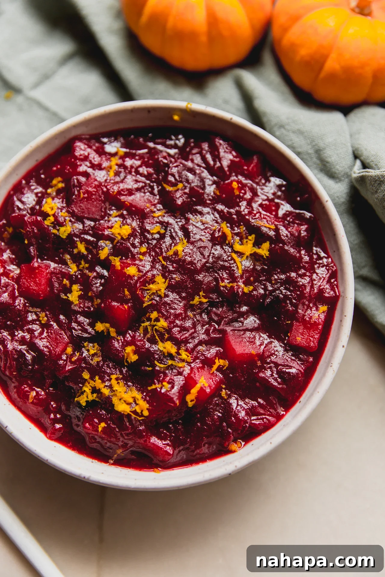 Apple cranberry sauce in a bowl topped with orange zest.