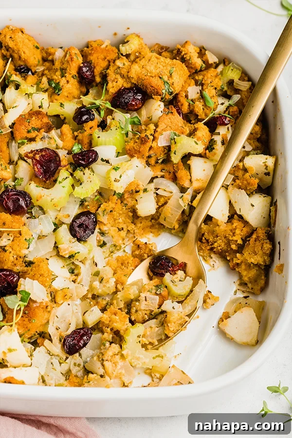 Hearty Paleo Thanksgiving Cornbread Stuffing AIP and Grain Free 3 A close-up of a platter of cornbread stuffing with a serving spoon.