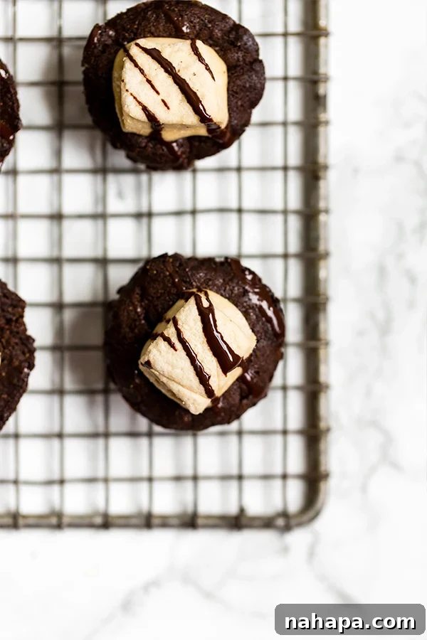A tray of paleo brownie bites topped with melted marshmallows and a chocolate drizzle.