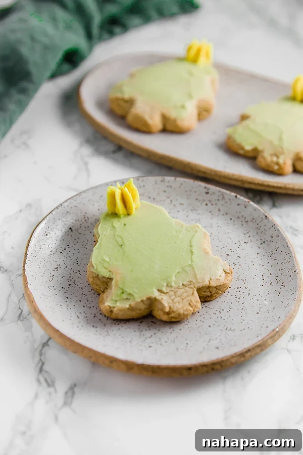 A grey speckled plate with a Christmas tree sugar cookie cut out with green icing and a yellow star on it. These are Paleo and AIP friendly.