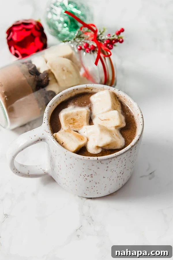 Jars filled with DIY Collagen Hot Cocoa Mix, topped with homemade peppermint marshmallows.