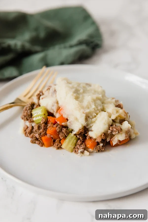 Comforting Cauliflower Shepherds Pie (Paleo, Whole30, AIP) 4 A beautifully presented serving of Cauliflower Shepherd's Pie on a white plate, ready to be enjoyed.