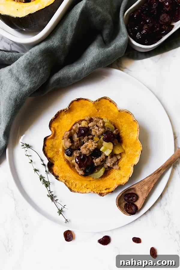 Paleo Whole30 AIP Stuffed Acorn Squash 2 A plate with a beautifully presented stuffed acorn squash, accompanied by a wooden spoon, showcasing its rich filling.