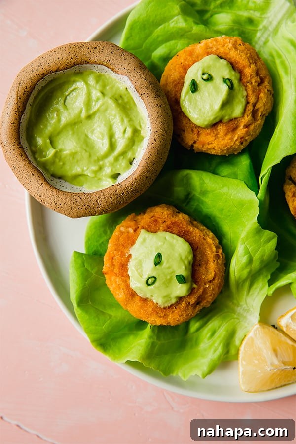 Plate of Sweet Potato Crab Cakes topped with green onions and horseradish avocado mayo