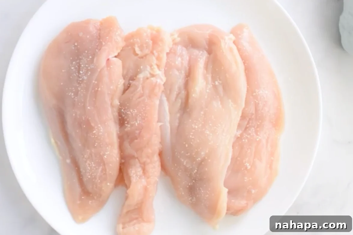 Thinly sliced chicken cutlets seasoned and coated in arrowroot starch on a plate.