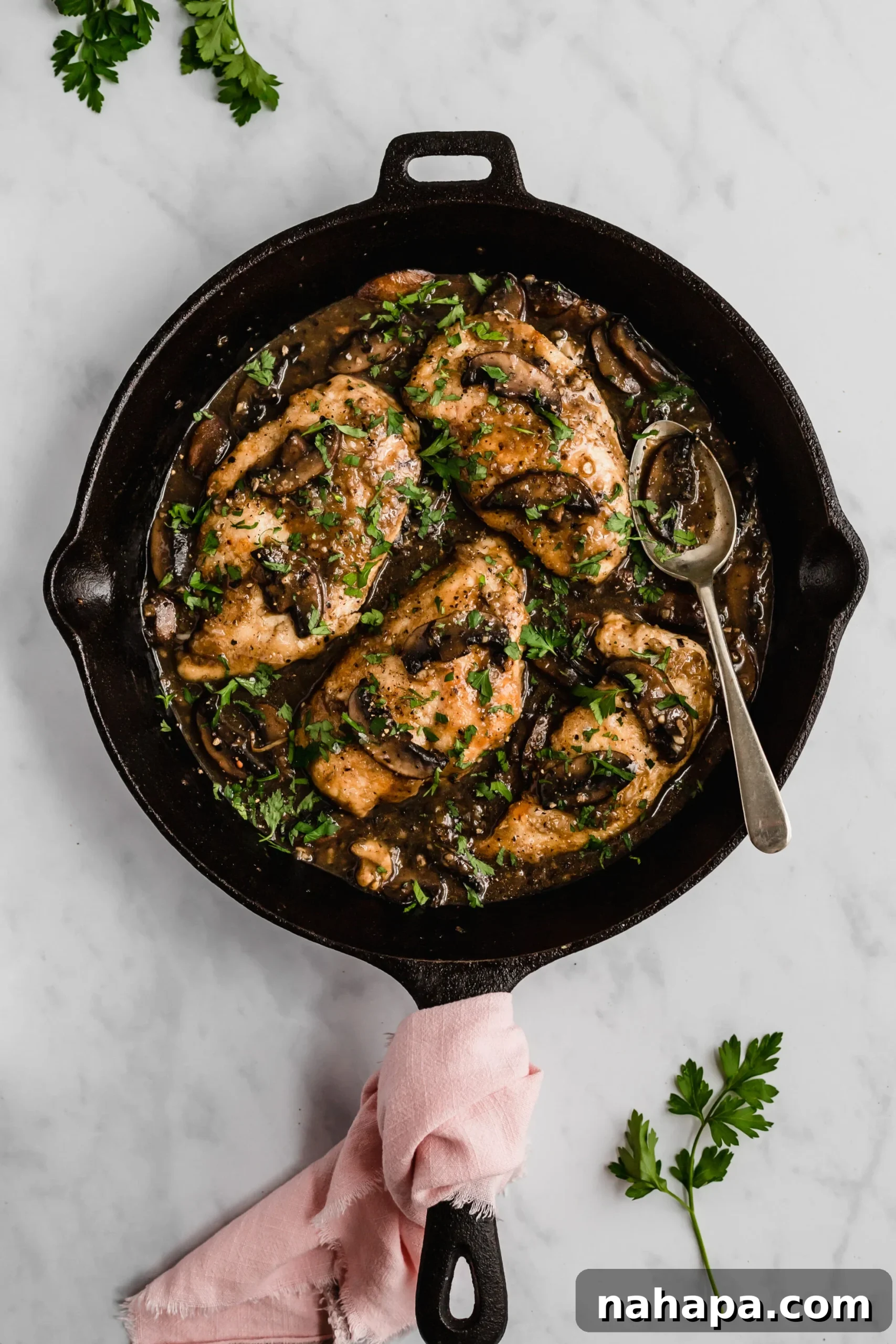 Gluten-free chicken marsala served with fresh parsley, highlighting the rich, savory sauce.
