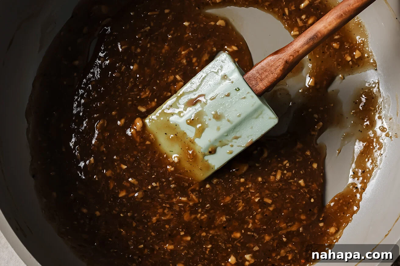 Teriyaki style sauce cooked in a pan with a spatula. 