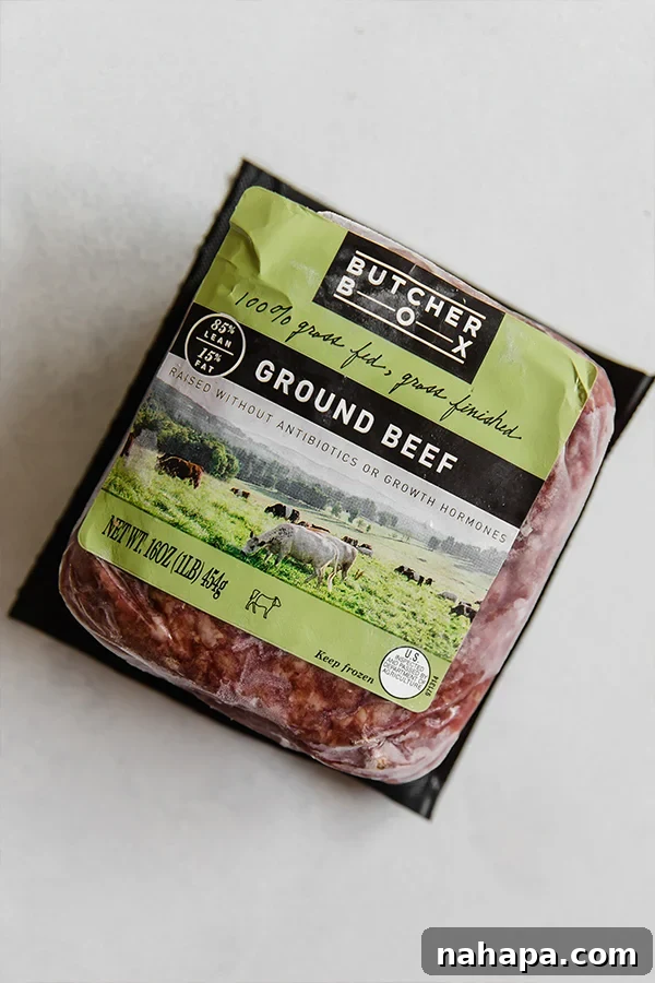 A package of frozen Butcher Box ground beef sitting out on a container.