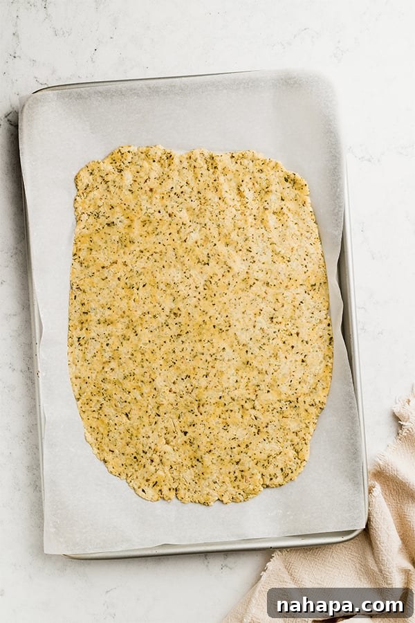Grain-Free and Dairy-Free Cauliflower Breadsticks: Paleo and AIP Compliant 5 The cauliflower dough skillfully spread into a rectangular shape on a baking sheet, ready for baking.
