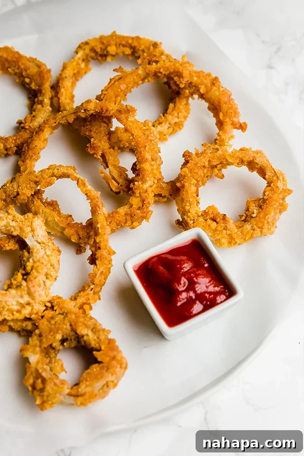 Crispy baked onion rings, coated in a grain-free and nightshade-free batter, a healthy snack alternative.