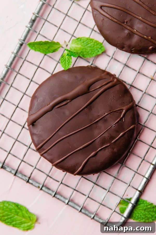 A paleo thin mint on a metal cooling rack with fresh mint next to it.
