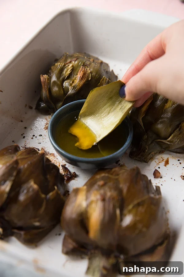 A whole artichoke and various ingredients laid out for preparation