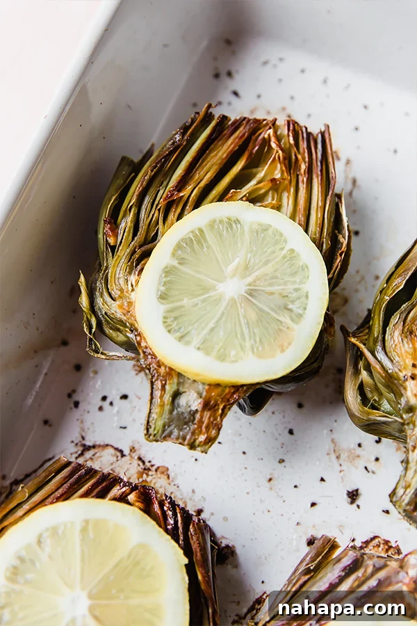 Close-up of baked artichoke halves garnished with fresh lemon