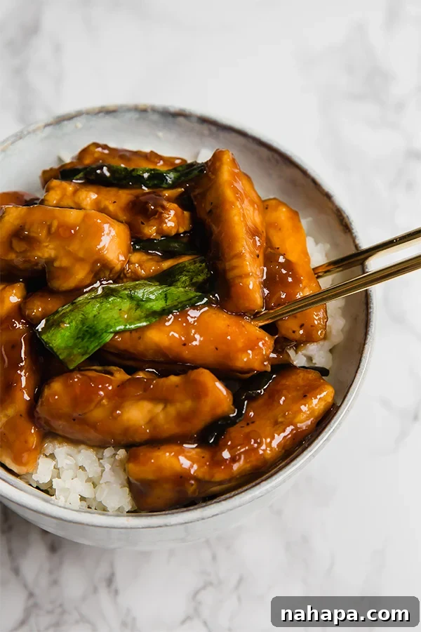 Close-up of crispy Paleo Mongolian Chicken pieces in a rich, glossy sauce