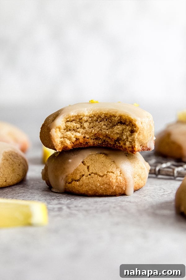 Close-up of a stack of Paleo Lemon Cookies, highlighting the texture and delicate lemon zest on top.