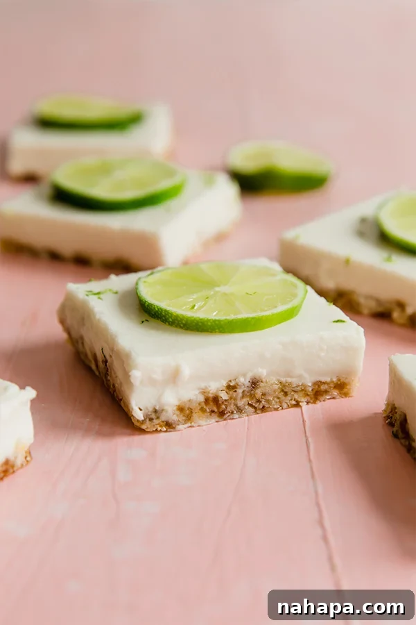 Delicious and zesty Paleo Key Lime Pie Bars cut into squares, garnished with fresh lime slices