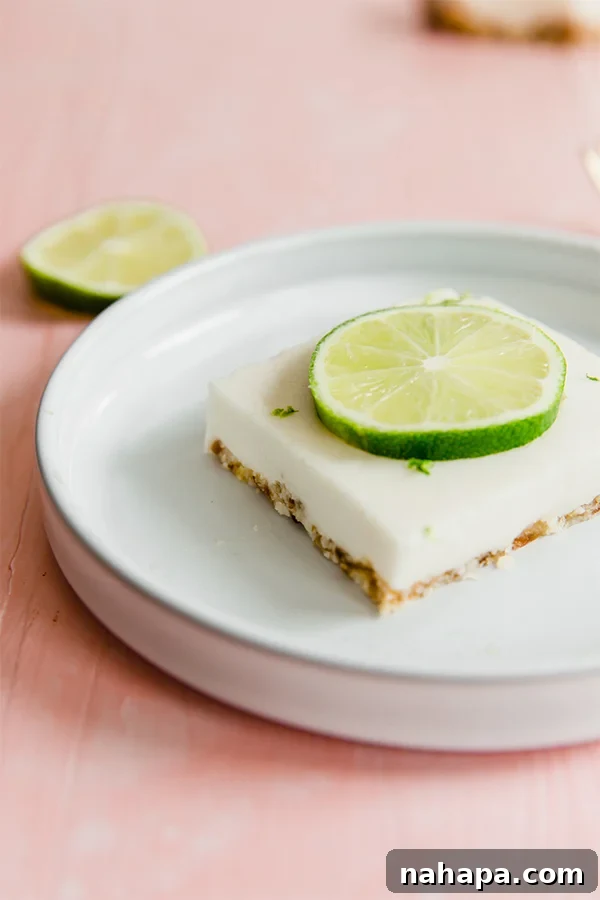 A tray of perfectly set Paleo Key Lime Pie Bars, ready to be cut, showcasing the vibrant green color of the filling