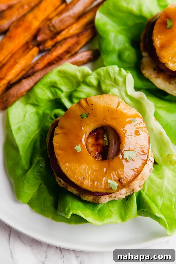 Paleo Whole30 AIP Tropical Teriyaki Chicken Burgers 6 A beautifully composed shot of Hawaiian Teriyaki Chicken Burgers, showcasing the grilled pineapple, fresh cilantro, and homemade teriyaki sauce.
