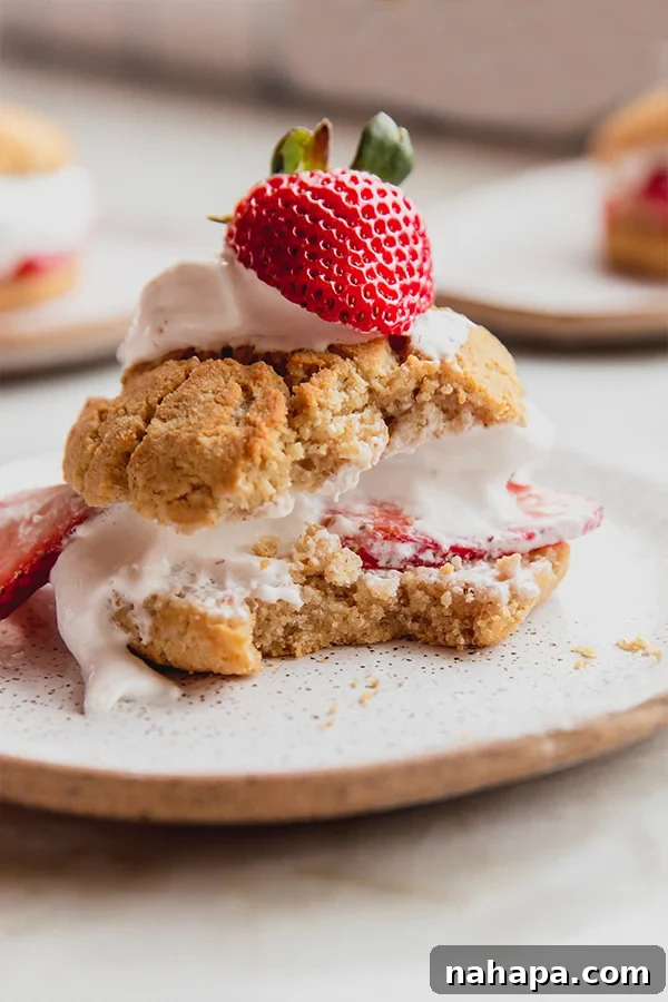 Freshly assembled Paleo Strawberry Shortcake with whipped coconut cream and sliced strawberries