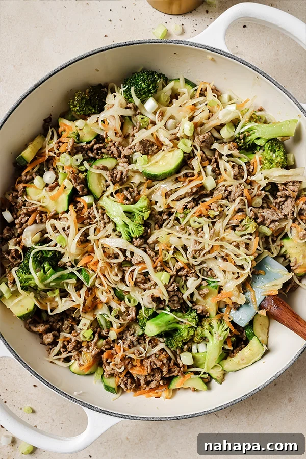 A large skillet filled with ground beef and cabbage stir fry after having been cooked.