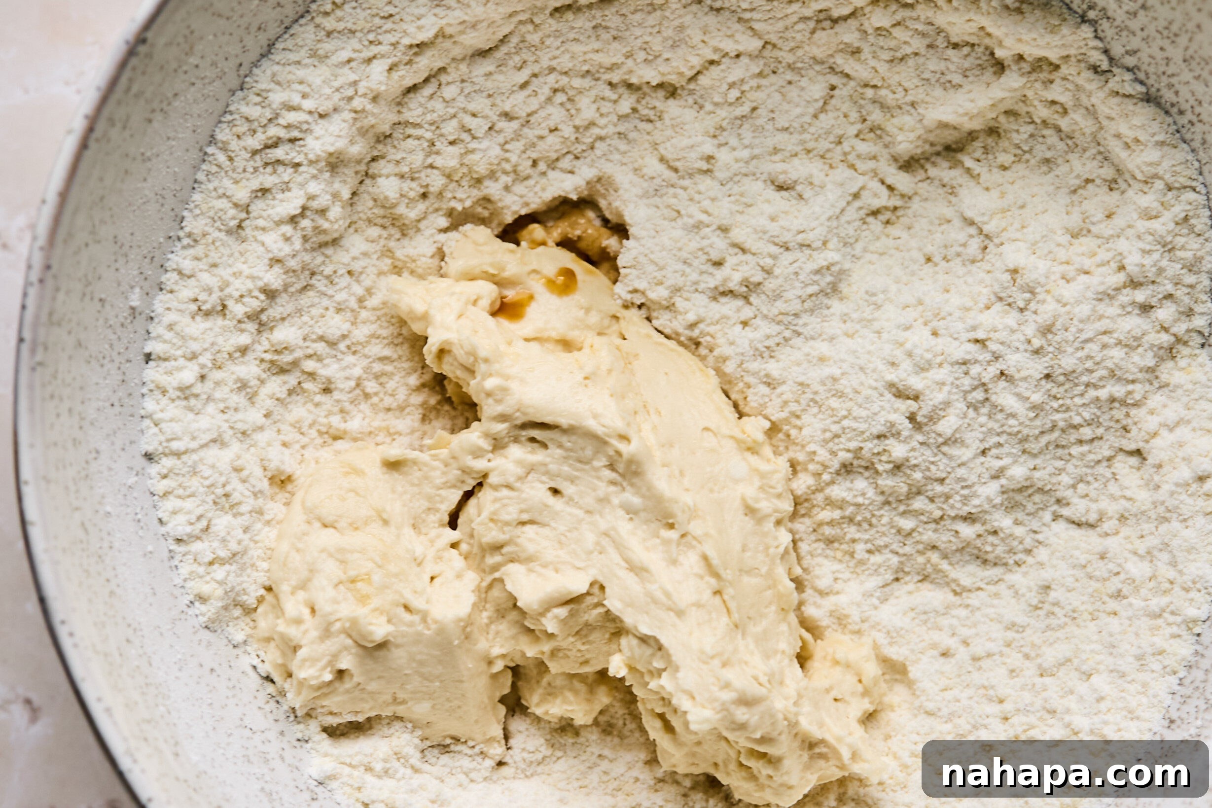 Wet ingredients being mixed and then added to dry ingredients to form cookie dough.