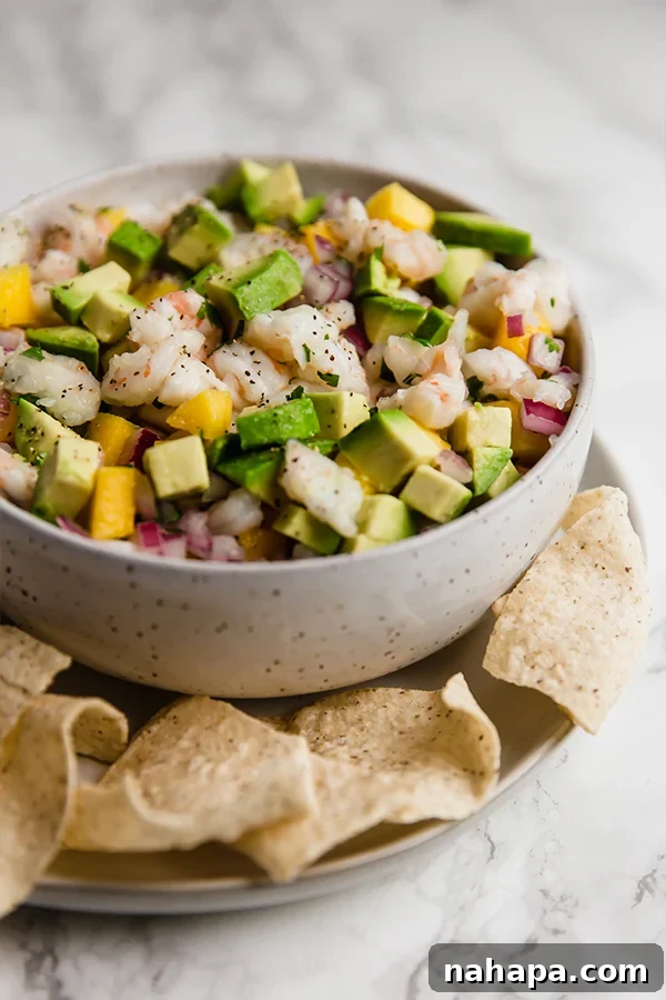 Bright and colorful mango shrimp ceviche in a bowl, garnished with fresh cilantro.