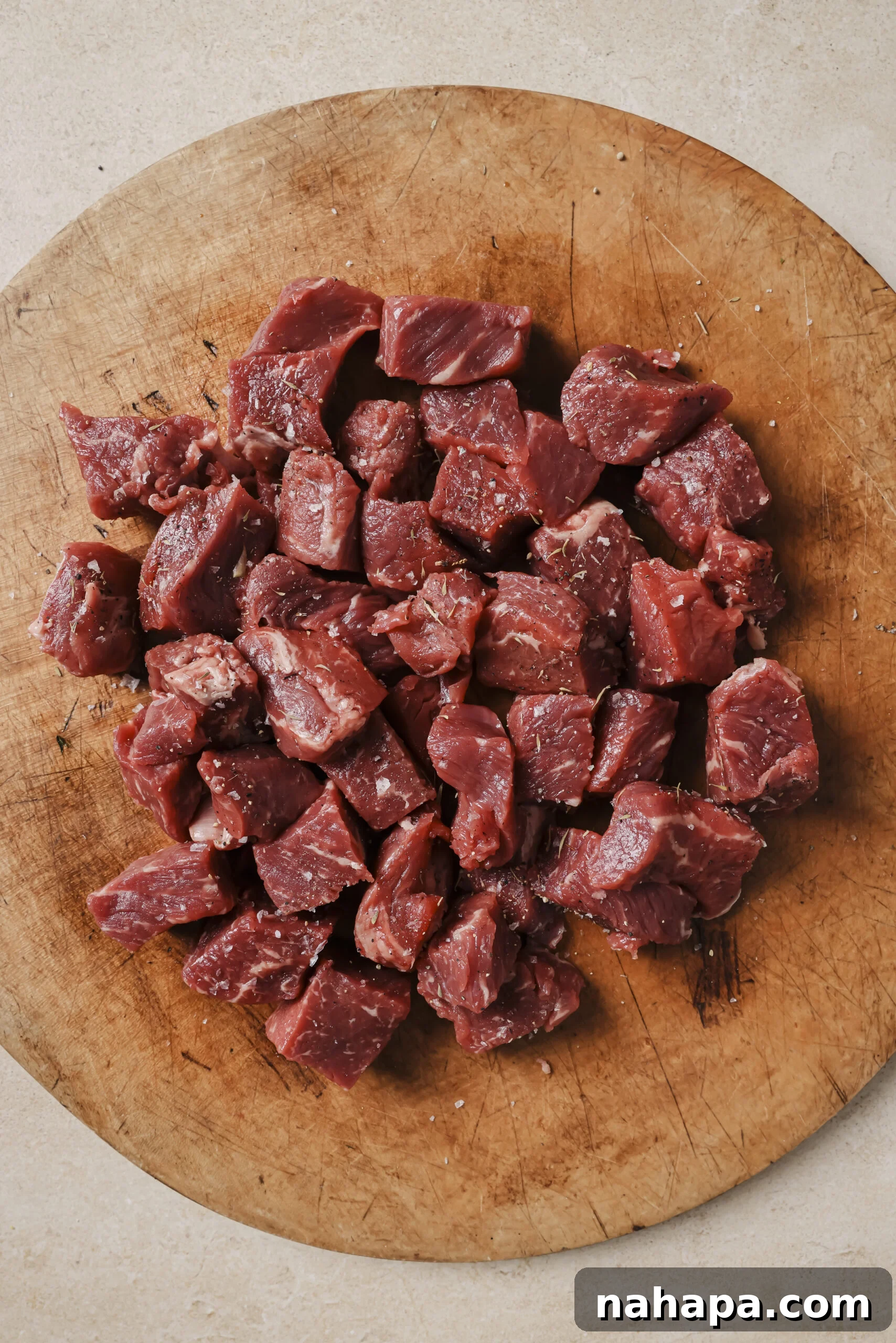 Bite-sized pieces of steak on a wooden board.