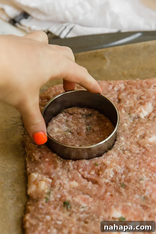 Close-up of freshly prepared turkey breakfast sausage patties on a baking sheet, ready for cooking.