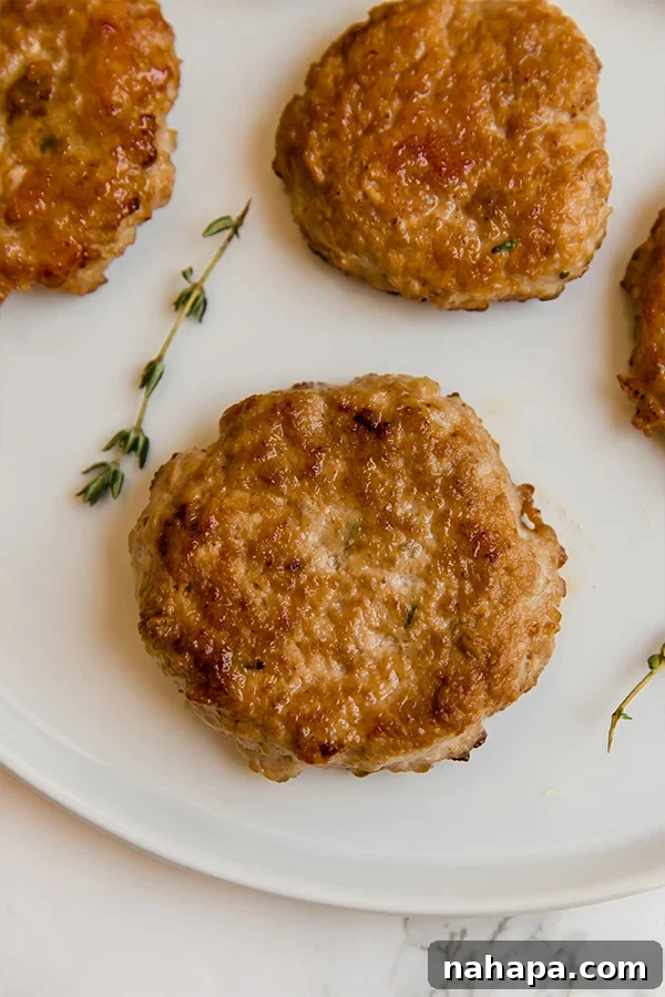 A plate of cooked turkey breakfast sausages garnished with fresh herbs, ready to be served.