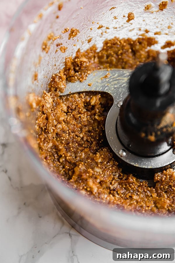 A close-up of the smooth fig newton filling mixture in a food processor, ready for assembly.