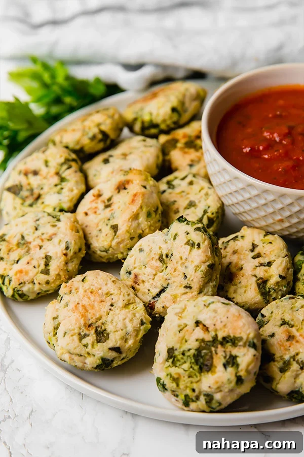 A serving of freshly baked Italian Chicken Poppers arranged on a plate with dipping sauce, ready to be enjoyed.