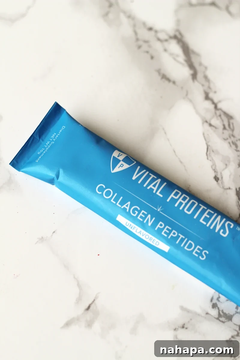 A single serve packet of collagen on a white marble background.