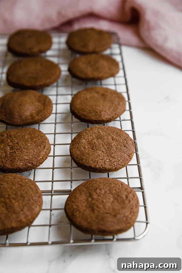 A baking sheet with freshly baked homemade Oreo cookies cooling down on a wire rack.