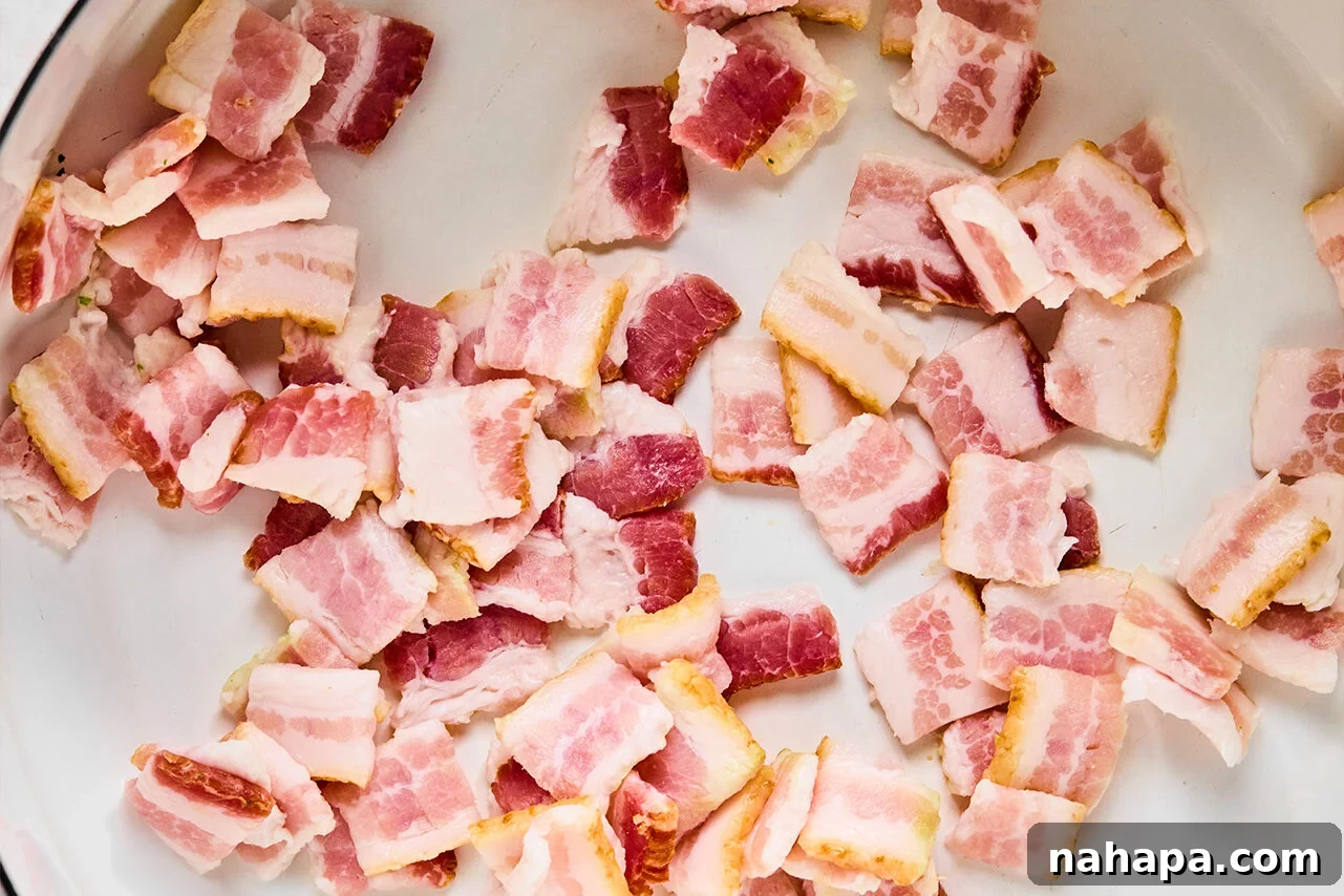 Bacon sauting in a pan on the stove.