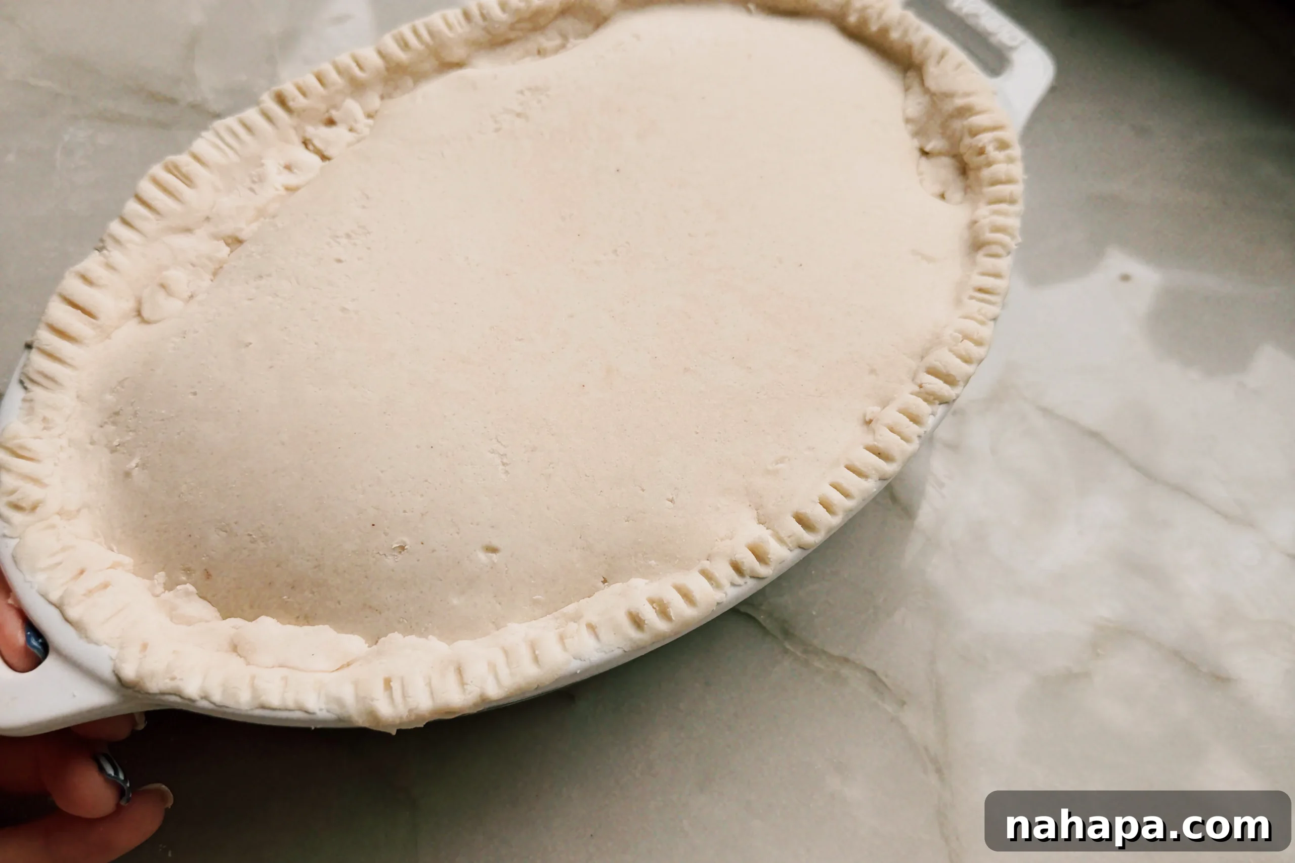 Dough crimped over the beef filling before going into the oven.