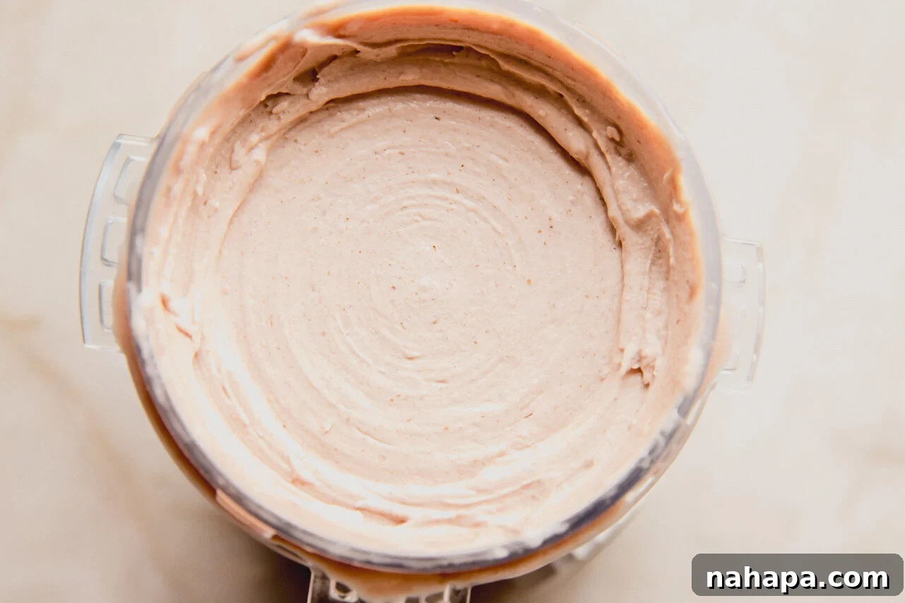 The Ninja Creami pint container filled with the blended ice cream base, ready to be frozen, showing its slightly thickened pre-frozen state.