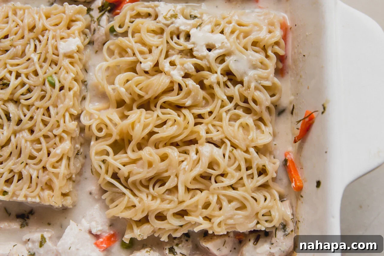 The casserole dish with ramen, vegetables and chicken with arrowroot starch and chicken broth poured over it.