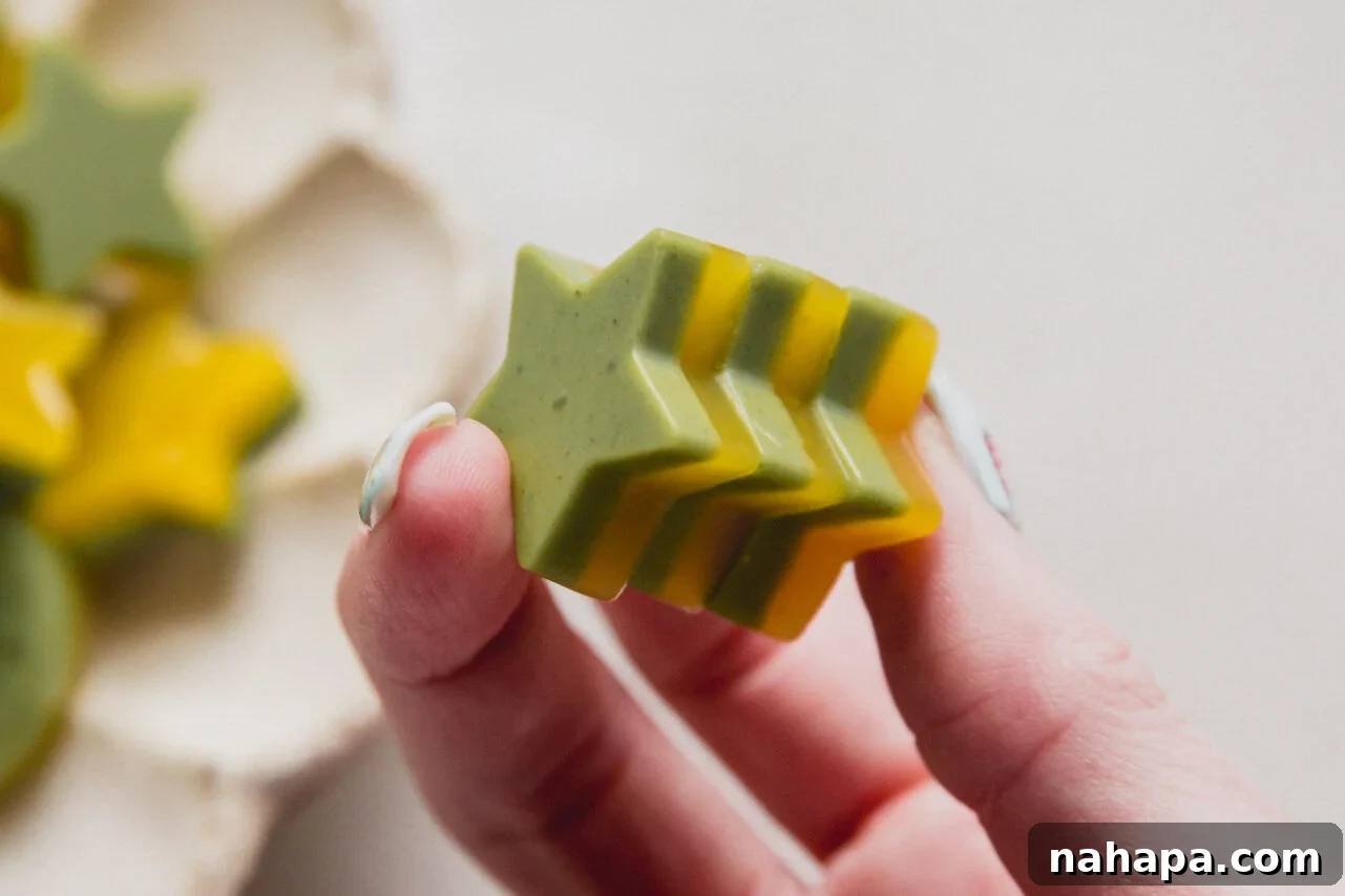 A hand holding mango matcha gummies in it.