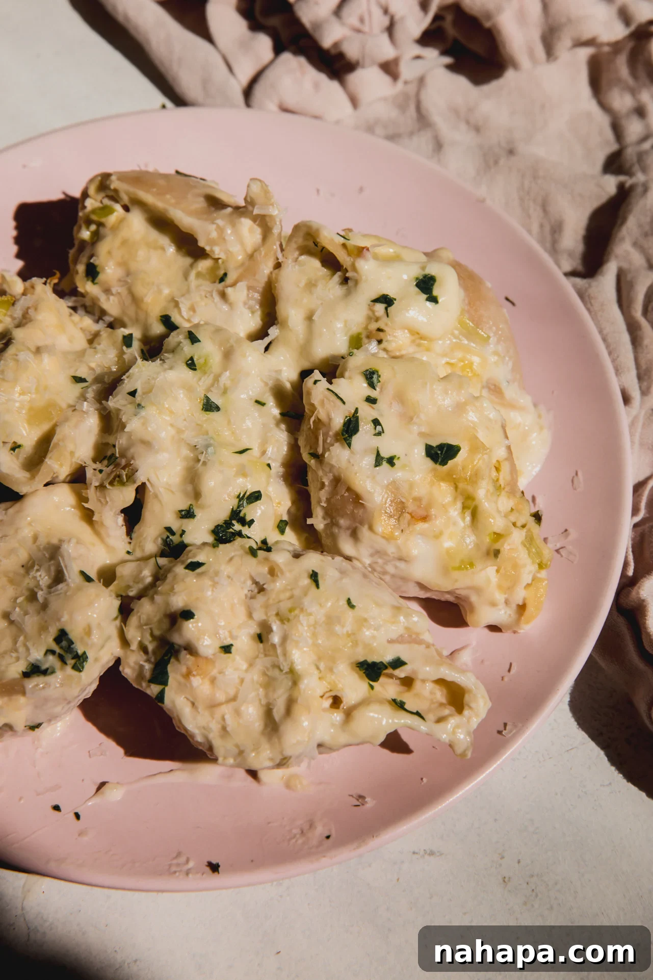Luscious Dairy-Free Chicken Stuffed Shells 9 A pink plate filled with several stuffed shells.