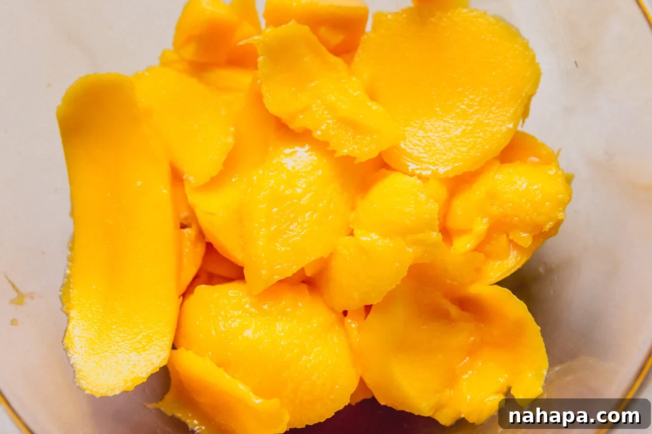 A blender with mango chunks before blending it.