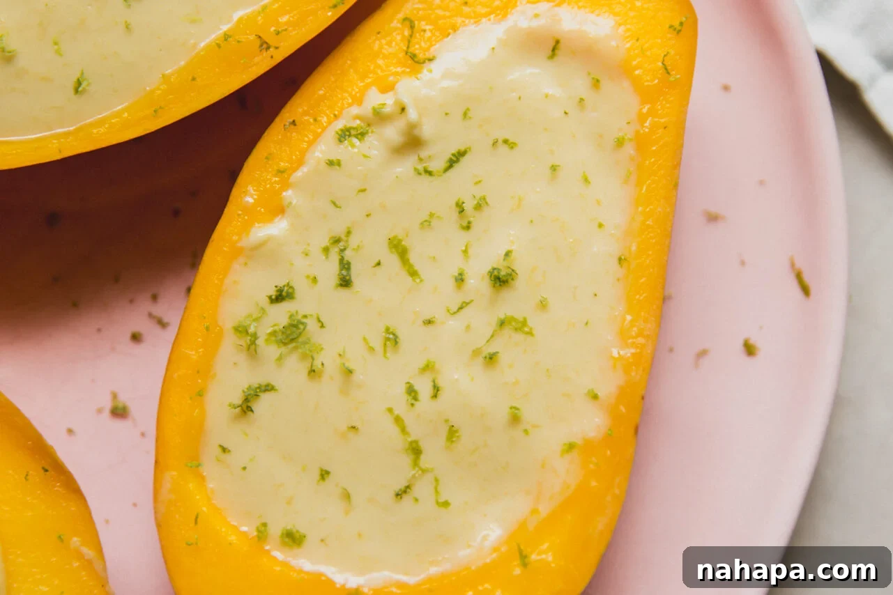 Mango posset topped with lime zest sitting on a pink plate.