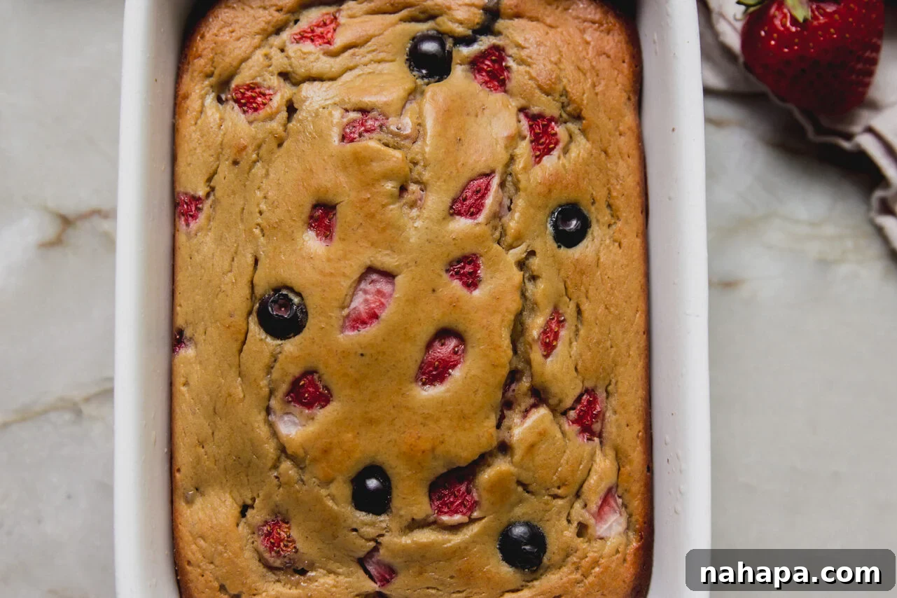 Berry protein breakfast cake in a small ceramic baking dish.