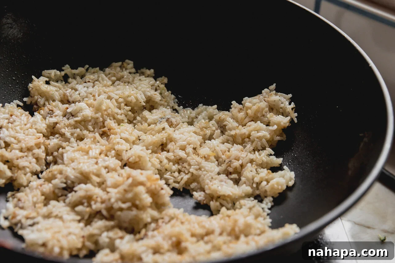 Beef and Broccoli Fried Rice Recipe with Garlic Soy Flavor 7 A wok filled with rice heating in it.